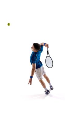 Tenis oyuncusu, mavi-beyaz üniformalı adam güçlü bir servis atışı sergiliyor ve beyaz stüdyo arka planında topa uzanıyor. Hava görüntüsü. Spor, turnuva, güç, oyun kavramı