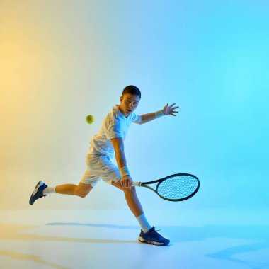 Şık üniformalı sporcu topa vuruyor, raketi sıcak neon ışıkta canlı mavi-sarı gradyan arka planda tutuyor. Spor anlayışı, konsantrasyon, beklenti, eşleşme