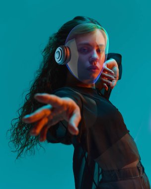 Şeffaf neon kasklı bir kadının kavramsal yüksek çözünürlüklü kolajı fütürist arka plan altında dramatik bir jest olarak öne çıkıyor. Dijital sanat kavramı, editoryal tasarım