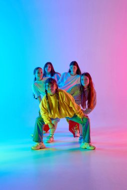 Genç şehir dansçıları canlı enerji ve dinamik takım ruhunu renkli bir stüdyo arkaplanında yayarlar. Dansta gençlik ifadesi ve birlik kavramı.