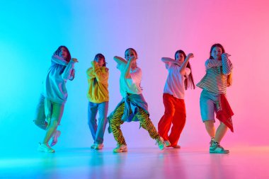 Bir şehir dans grubu renkli ışıklar altında enerjik gençlik enerjisi ve yaratıcı ifade sergiliyor. Modern dans kültürü ve sanatsal dinamizm kavramı.