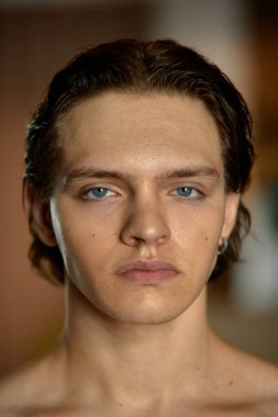 Çok az. Mavi gözlü ve kendine güvenen genç bir adam. Keskin göz teması. Sadece kaş şekilli, başka bir şey değil. Özgüven ve içsel güç kavramı.