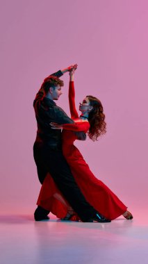Arjantinli bir tango çifti pembe bir stüdyo arkaplanına karşı zarif bir poz veriyor. Dans yoluyla tutku, ritim ve kültürel ifade kavramı.