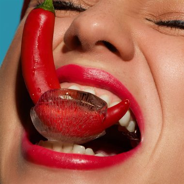 Gülen kadın buzda donmuş biber yerken yüzünde neşeli bir ifade vardı. Sıcaklık, duygu, yoğunluk ve duyusal aşırılıklar kavramı cesur gerçeküstü güzellik..