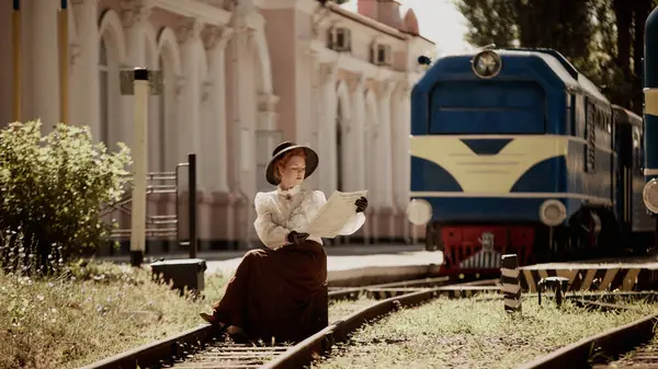 Tren ve istasyon yakınlarında raylarda oturmuş gazete okuyan eski moda elbiseli bir kadın. Psikolojik portre kitabı, kurgu kapağı, kültürel seyahat illüstrasyonu kavramı.
