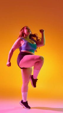 Canlı arka plan renklerine karşı çalışan enerjik bir kadın. Patlayıcı hareket, cesur kadın gücü spor kıyafetleri için enerjik markalaşma, duygusal beden gücü..