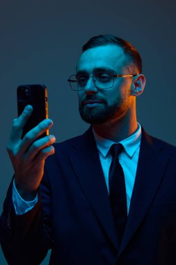 Çağdaş mavi şimşekler arasında akıllı telefon kullanan bir iş adamı. Fintech hizmet tanıtımı, engelleme zinciri yenilik pazarlaması ve kişisel finansman için dijital yatırım araçları kavramı.