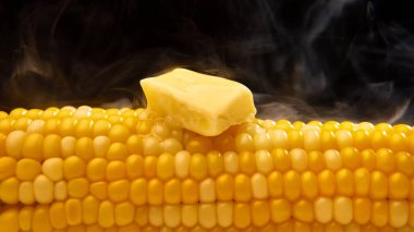 Eriyen tereyağlı buharda pişmiş mısır. Rahatlatıcı yemekler, lezzetli atıştırmalıklar, sağlıklı yemekler, yaz yemekleri ve mutfak reklamları..