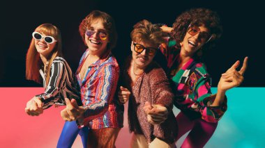 Retro disko arkadaşları canlı vintage kostümler içinde birlikte gülüyorlar. Popüler kültür nostaljisi, yaşam tarzı pazarlaması, eğlenceli moda markalaşması ve acayip kültürel reklamcılık kavramı..