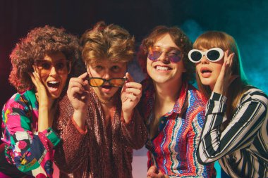 Arkadaşlığımızı kutlamak için cesur disko kostümleriyle gülümseyen bir retro grubu. Klasik tarz kavramı, nostaljik popüler kültür kampanyaları, yaşam tarzı tanıtımı ve birlikte ifade etmenin neşesi..