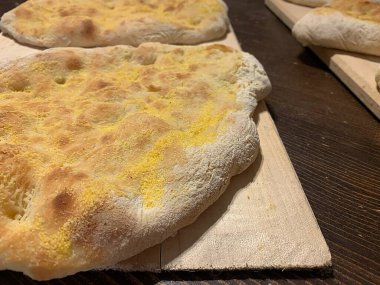 Italian pinsa, baked pancakes for pinsa, baked small pizzas arranged on a board, pancakes baked with flour, Italian pastry, Roman pinsa