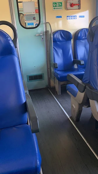 train interior, seats in the train, modern blue seats in the means of transport, railway compartment, emergency brake, door to the second car