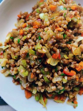 karabuğday ve doğranmış sebze, kızarmış soğan ve kereviz homurtusu ile çeşnilendirilmiş, rengarenk sebzeler kesilmiş ve kızartılmış, sağlıklı Groats.