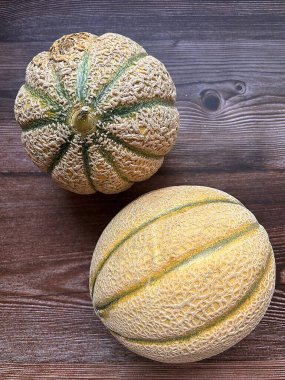 kavunlar, yuvarlak kavunlar, retato kavunu, ahşap bir arka planda meyve, taze meyve, sulu meyve, Akdeniz meyvesi, yuvarlak bir meyve