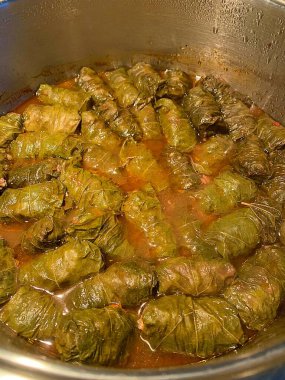 Dolma hazırlama, üzüm yapraklarına sarılmış et, üzüm yaprağı ruloları, tencereye yerleştirilmiş üzüm yaprağı ruloları.