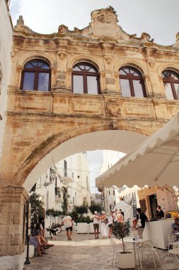 İki bina arasında geçiş kapısı, iki cadde arasında geçiş kapısı, Locorotondo kasabası, Puglia, İtalya, turizm kasabası, tarihi binalar