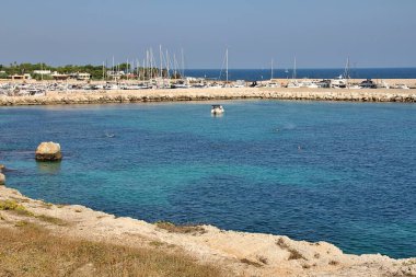 Puglia 'nın kayalık kıyıları, turkuaz su, güney Adriyatik kıyıları, güney İtalya, şeffaf deniz, küçük körfez, kıyıya demir atmış tekneler.