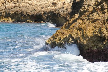 Deniz dalgaları, huzursuz deniz, kayalara çarpan dalgalar, deniz kenarındaki sivri kayalar.
