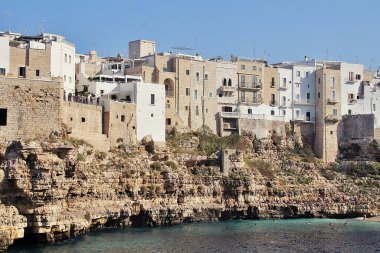  Deniz kenarındaki kayalar, deniz kıyısındaki kayalara inşa edilmiş binalar Polignano a Mare, kayalık kıyı, turkuaz su, deniz kenarındaki kayalar, deniz kıyısındaki kayaların üzerine inşa edilmiş binalar, turkuvaz suyu, denizde yıkanan insanlar.