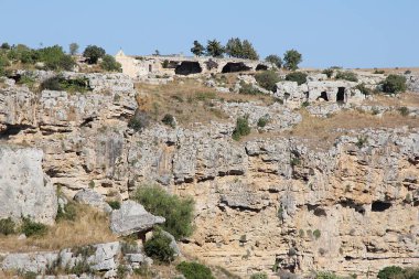 Kayalara oyulmuş mağaralar, antik bir şehrin kalıntıları, oyulmuş çukurları olan bir tepe, bir kaya dağı.