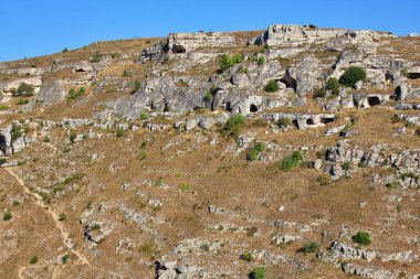 Kayalara oyulmuş mağaralar, antik bir şehrin kalıntıları, oyulmuş çukurları olan bir tepe, bir kaya dağı.