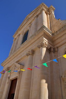  Kilise binası, sütunlar, eski bina, iyonik sütunlar, askıya alınmış renkli çelenkler, mavi gökyüzü, Locorotondo, İtalya