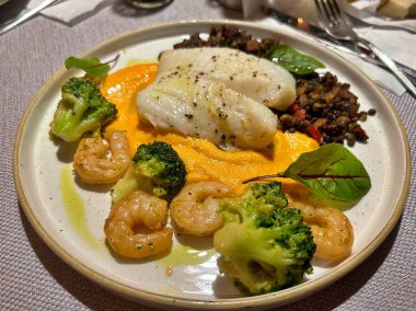 Restoranda tabak, balkabağı püresi, pastırmalı mercimek, meyve yaprağı, kızarmış karides.