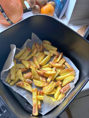 Kızartma makinesinde kızartma hazırlamak, patates dilimleri, altın kızartmalar, çıtır sebzeler.