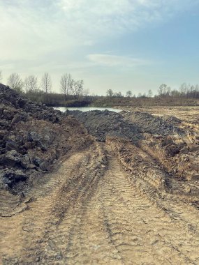 Taş ocağı, toprak kazısı, kazılardaki su, kazıcılar, toprak ve kumdan dağlar, kamyonların ezdiği toprak.