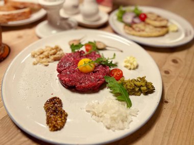 Tabakta tartar, çiğ et aperatifi, yumurta sarısı ve dilimlenmiş salatalık, biftek tartar.