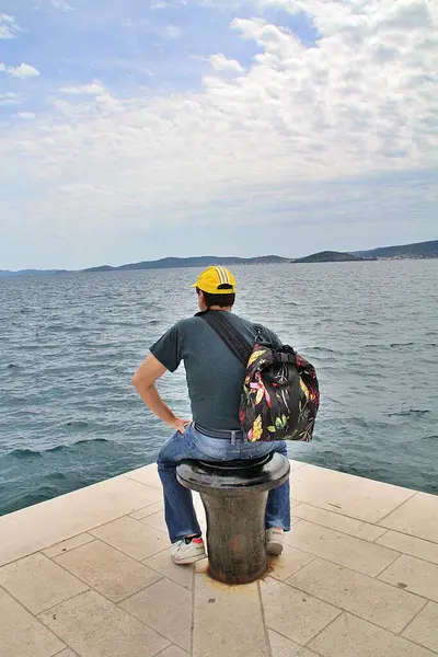 Sahilde oturan bir adam, deniz kenarına bakan bir adam, tefekkür.