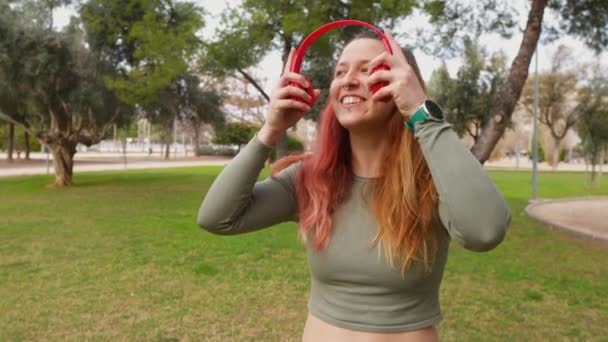 Uma Mulher Feliz Com Fones Ouvido Vermelhos Gosta Música Ambiente — Vídeo de Stock