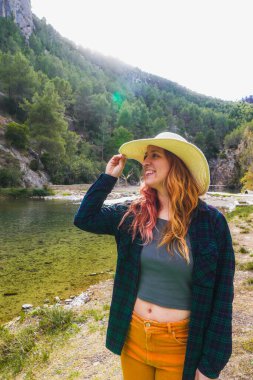 Gülümseyen kadın açık havada güneş şapkası takıyor..