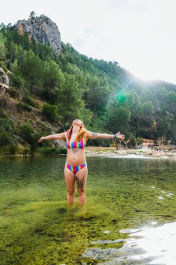 Bikinili kadın nehirde güneşin tadını çıkarıyor..