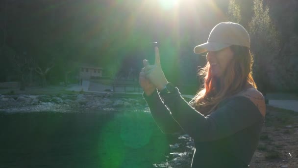 Sorrindo Mulher Tomando Uma Selfie Junto Rio Com Luz Sol — Vídeo de Stock