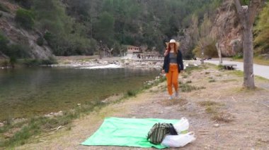 Bir gezgin, doğal güzelliklerle çevrili Montanejos 'da Mijares Nehri' nde piknik düzenler..