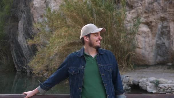 Веселий Чоловік Кепці Джинсова Куртка Біля Річки Посміхаючись — стокове відео