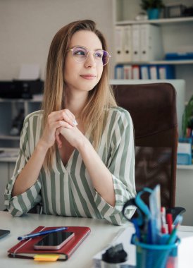 Ofisindeki bilgisayarda çalışan genç bir kadın.