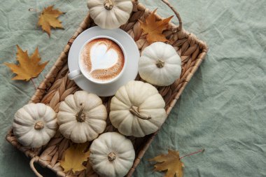 Hasır tepside beyaz balkabakları, kahve ve sonbahar yaprakları. Sonbahar ev dekorasyonu.
