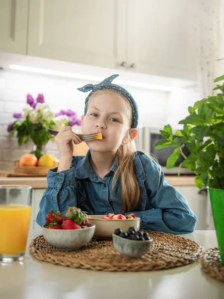 stock image Healthy food at home. Cute little girl eats fruit salad 