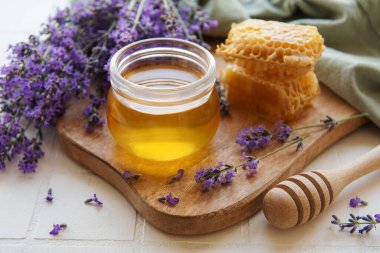 Glass of honey, honeycomb and lavender flowers