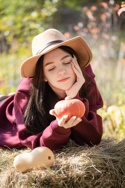 Biała Nastolatka Siedząca Jesiennym Parku Trzyma Rękach Pomarańczową Dynię Sezon — Zdjęcie stockowe