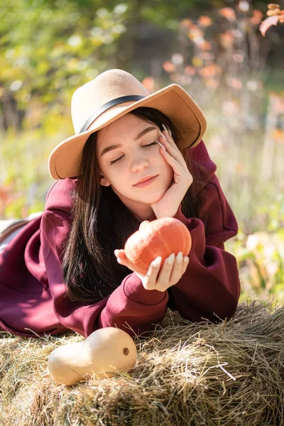 Biała Nastolatka Siedząca Jesiennym Parku Trzyma Rękach Pomarańczową Dynię Sezon — Zdjęcie stockowe