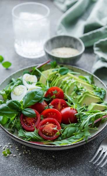 stock image Fresh summer salad with arugula,  red cherry tomatoes, basil, eggs and avocado. Vegan food. Healthy salad