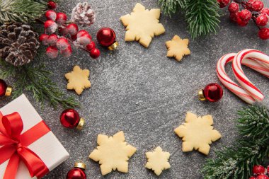 Noel arkaplanı zencefilli kurabiyeler, hediye kutuları ve koyu beton arka planda köknar dalları. Kış festivali konsepti. Düz yat, boşluğu kopyala.