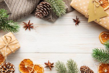 Beyaz ahşap arka planda bir çerçeve oluşturan hediyeli Noel süsü. Noel teması. Düz yat, boşluğu kopyala