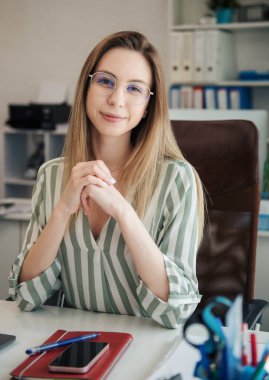 Ofisindeki bilgisayarda çalışan genç bir kadın.