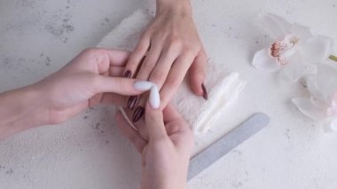 Tırnaklarında koyu kırmızı manikür olan genç bir kadının güzel elleri. Manikür süreci. 