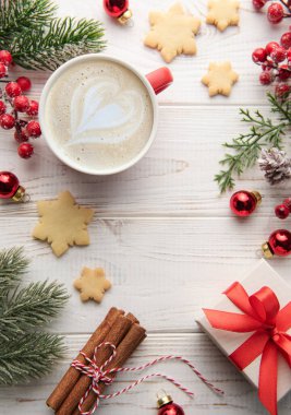 Beyaz ahşap arka planda bir fincan kahve ve Noel süsü. Noel ve yeni yıl kutlaması konsepti. Kopyalama alanı olan üst görünüm, düz yatay.