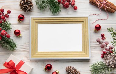 Noel kompozisyonu. Fotoğraf çerçevesi, dekorasyonlar, beyaz ahşap arka planda köknar dalları. Noel, kış, yeni yıl konsepti. Düz konum, üst görünüm, boşluğu kopyala